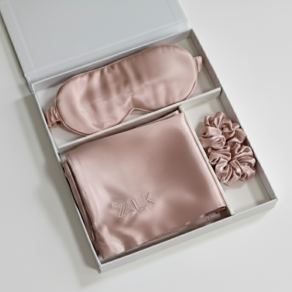 ZILK silk sleep kit in blush pink — includes silk sleep mask, pillowcase, and scrunchie made from 25-momme silver-infused silk.