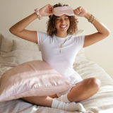 ZILK silk sleep kit in Lightpink styled on bed with pillowcase, mask, and scrunchies