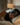 Brunette woman wearing a dark gray silk sleep mask over her eyes, laying on her side on an ivory silk pillowcase.