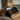Brunette woman wearing a dark gray silk sleep mask over her eyes, laying on her side on an ivory silk pillowcase.